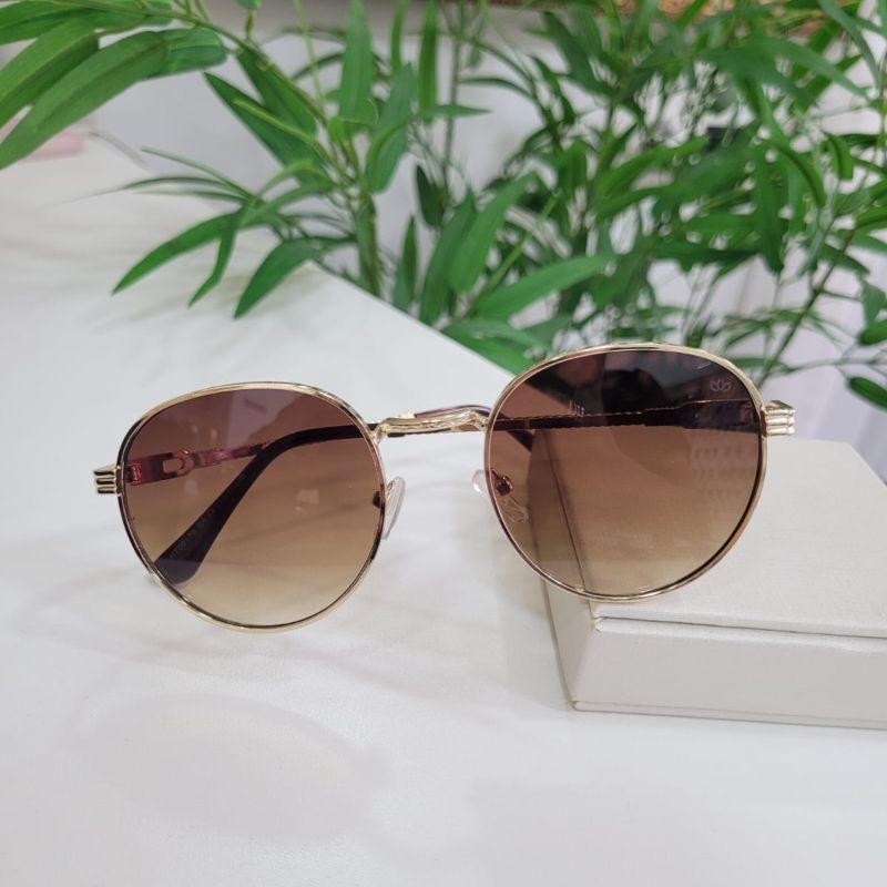 Oculos oval caramelo arrmacao dourada detalhado na perna