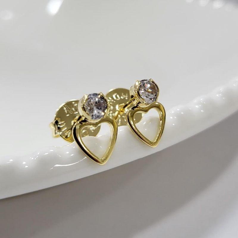 Brinco coracao vazado pequeno com uma pedrinha na cor cristal banhado a ouro 18k