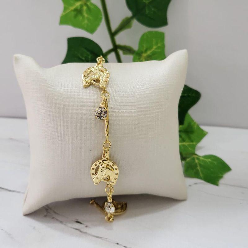 Pulseira tubinhos com pingentes ferradura pequena com cabeca de cavalo com tres pedrinhas na cor cristal banhado a ouro 18k