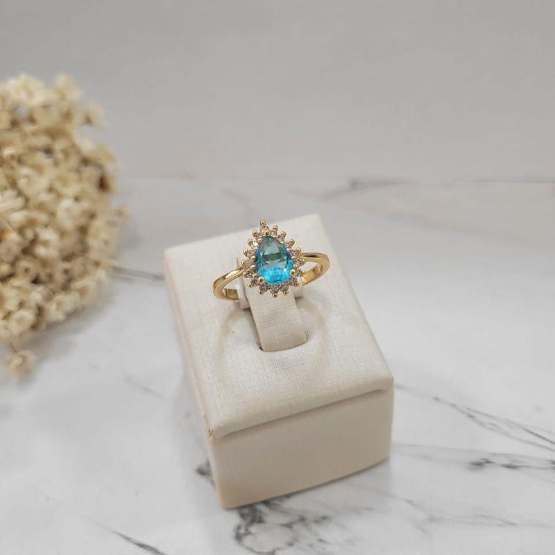 ANEL COM PEDRA GOTA AZUL CEU COM LATERAIS CRAVEJADO BANHADO A OURO 18K