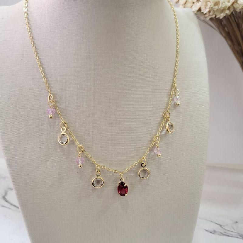 Chocker com uma pedrinha oval no meio na cor rubi quatro na cor cristal e quatro na cor quartzo rosa banhado a ouro18k TAM35CM