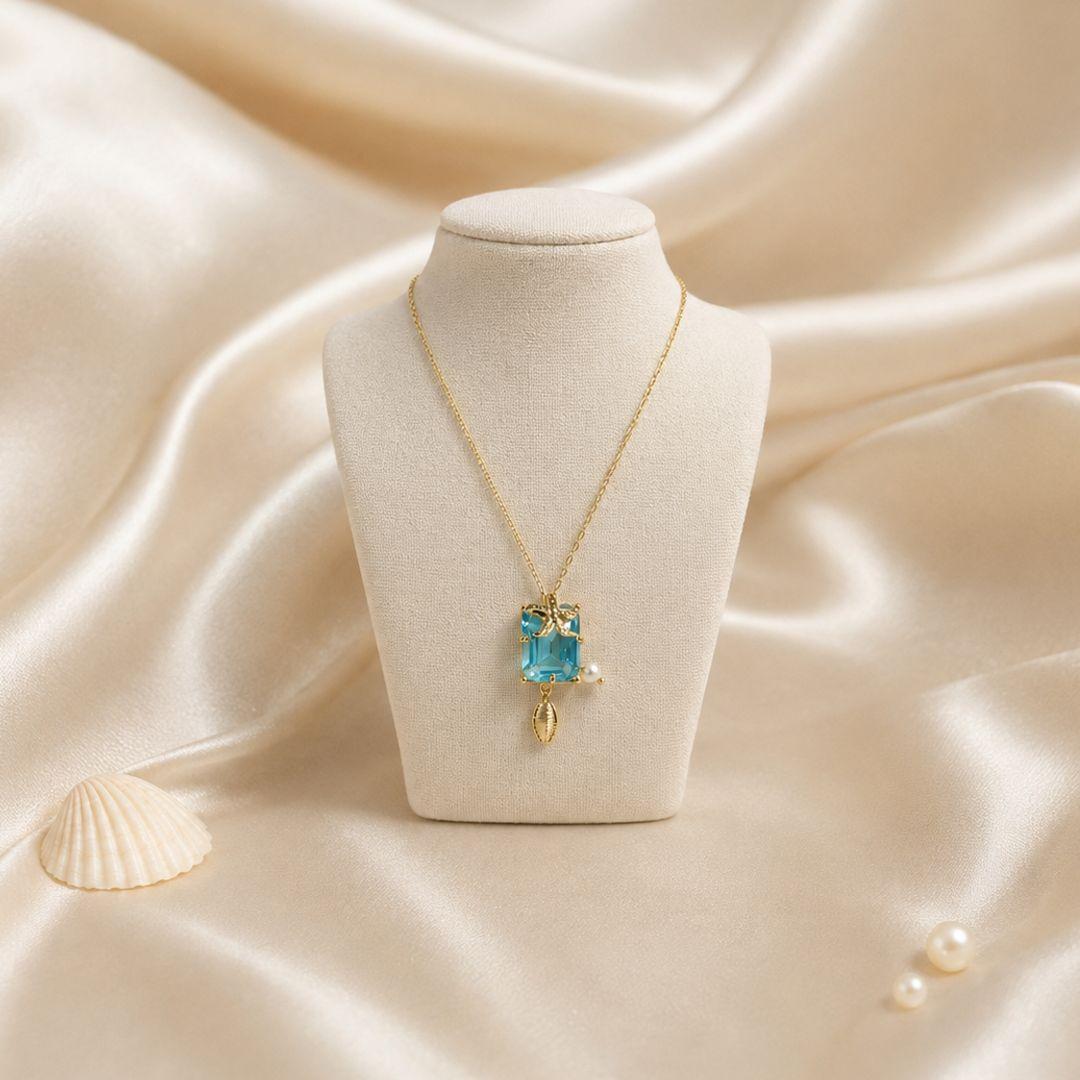 Gargantilha com pedra retangular na cor agata azul ceu com estrela do mar buzios e perola banhada a ouro 18k TAM45CM